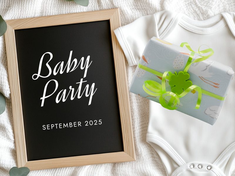 Geschenk mit grünem Kleeblatt-Clip neben einem Schild zur Babyparty