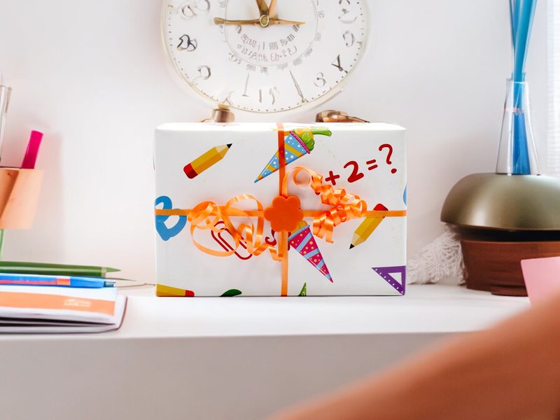 Geschenk zur Einschulung mit Ribbclip auf einem Schreibtisch